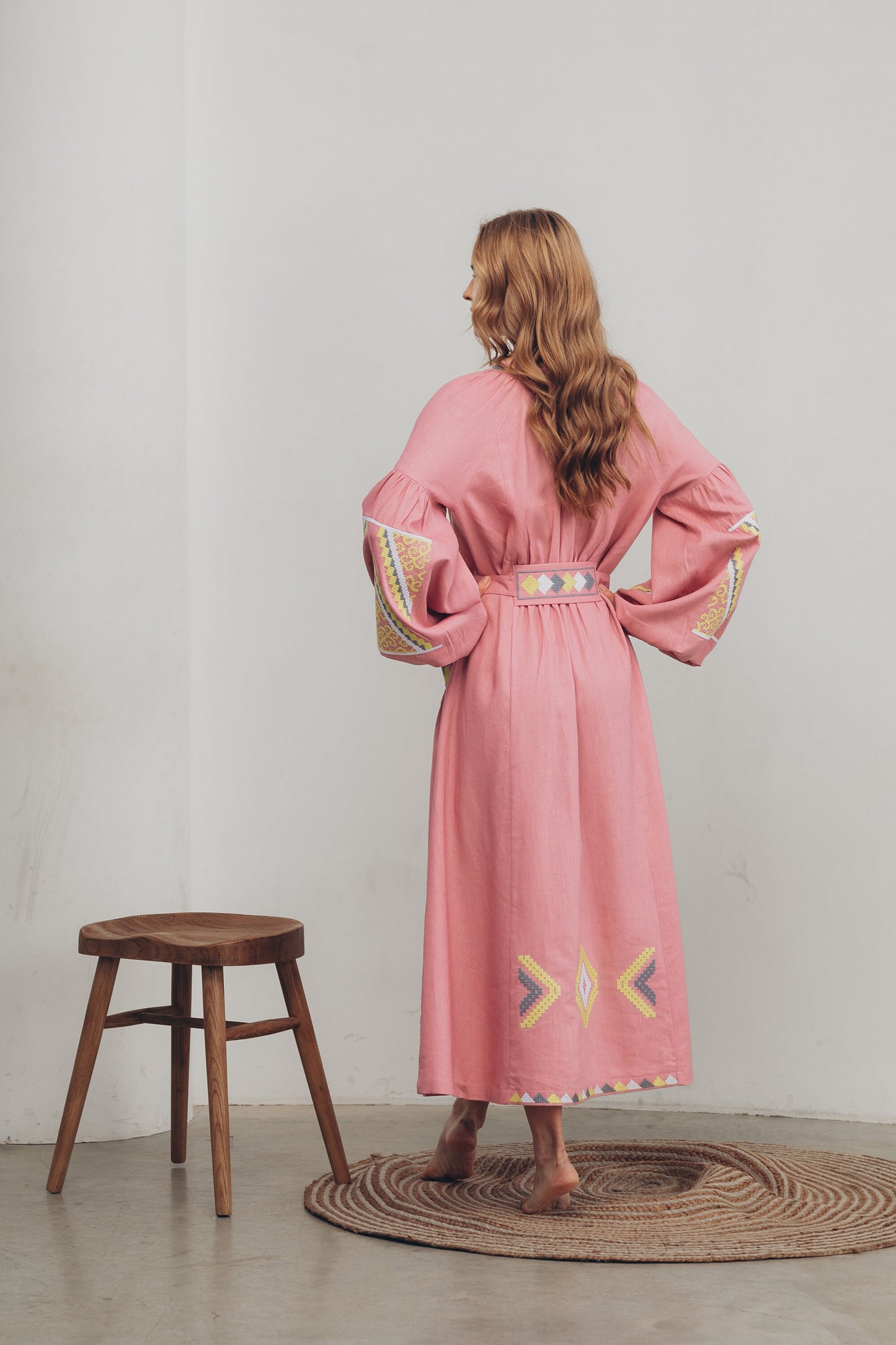 Back view of a pink linen embroidered Vyshyvanka dress featuring boho folk style with belt and pockets, inspired by Ukrainian tradition.