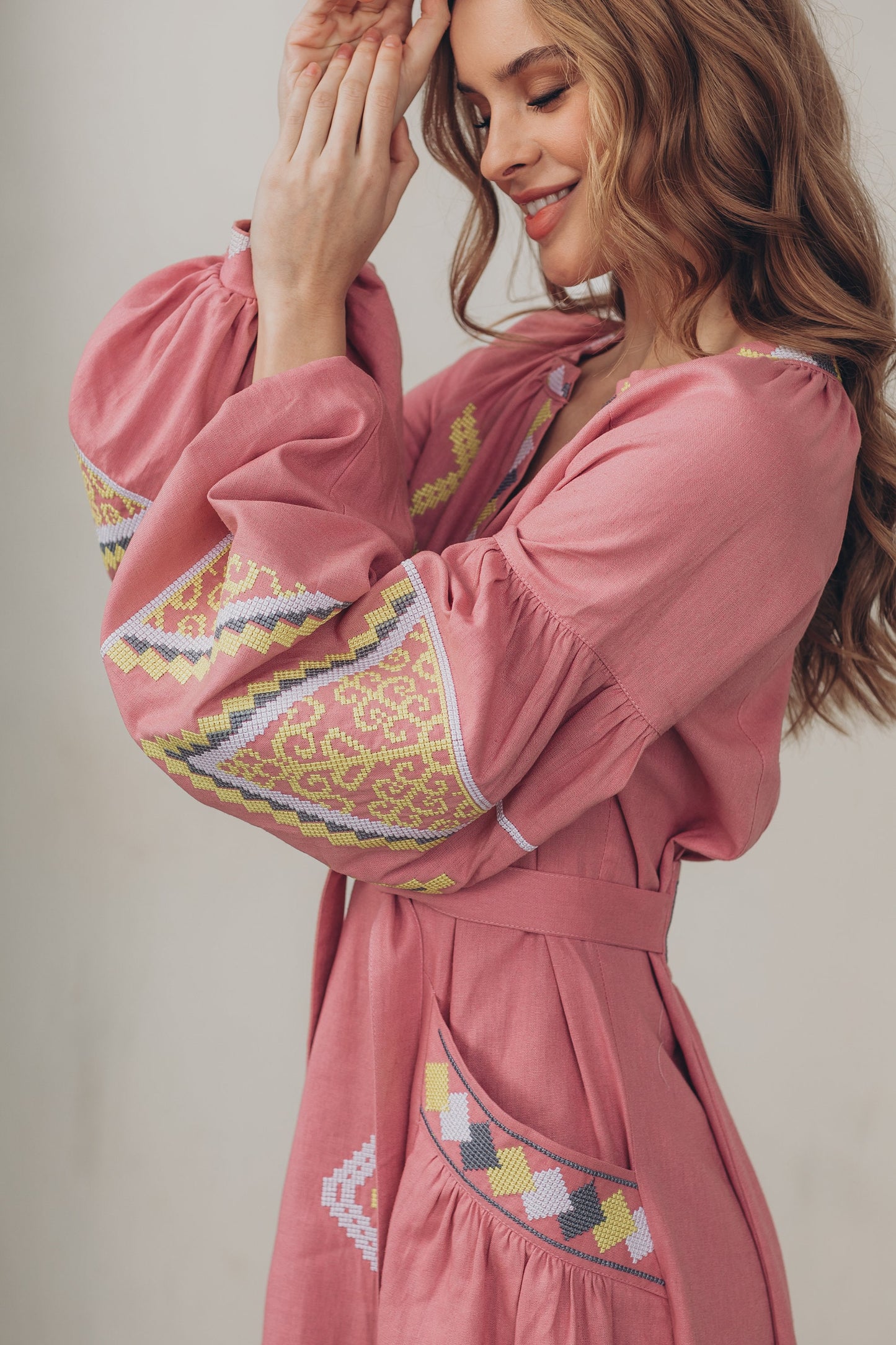 Pink linen embroidered Vyshyvanka dress in Ukrainian boho folk style with colorful patterns, belt, and pockets.