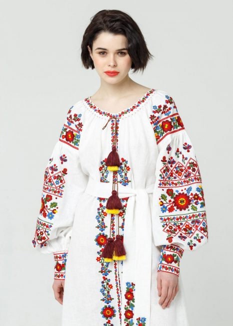 White embroidered Ukrainian Vyshyvanka wedding dress in boho style with colorful folk patterns, made from natural linen.