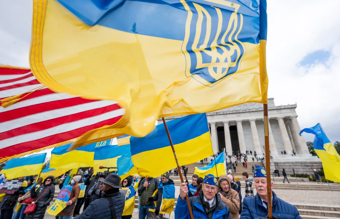 Crowd waving Ukrainian and American flags in front of Lincoln Memorial, symbolizing cultural unity and support for Ukraine.
