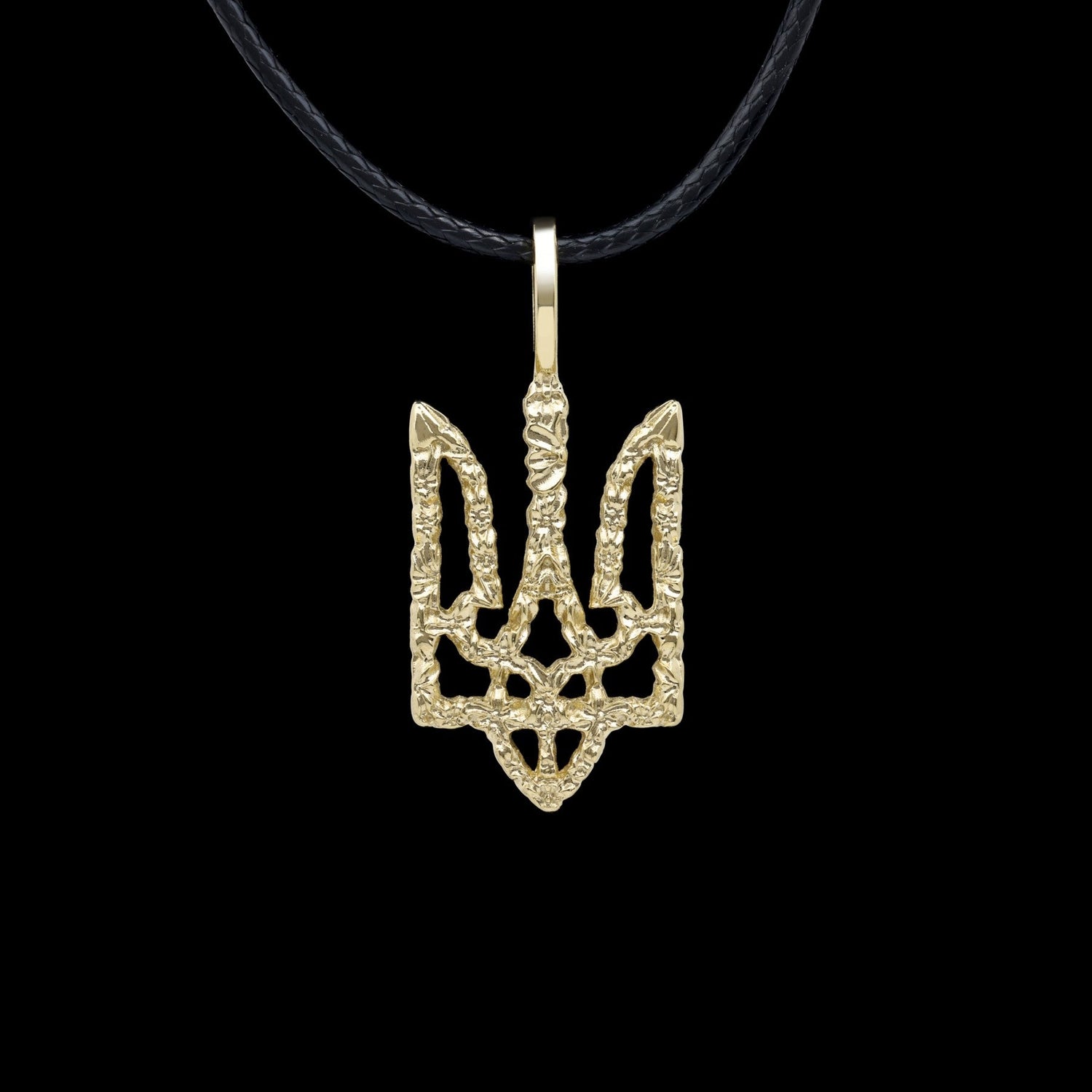 Gold trident-shaped pendant on black cord necklace against a black background.