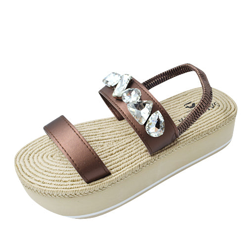 Stylish patterned slip-on shoes held against a minimalist background, showcasing unique footwear designs with artistic flair.