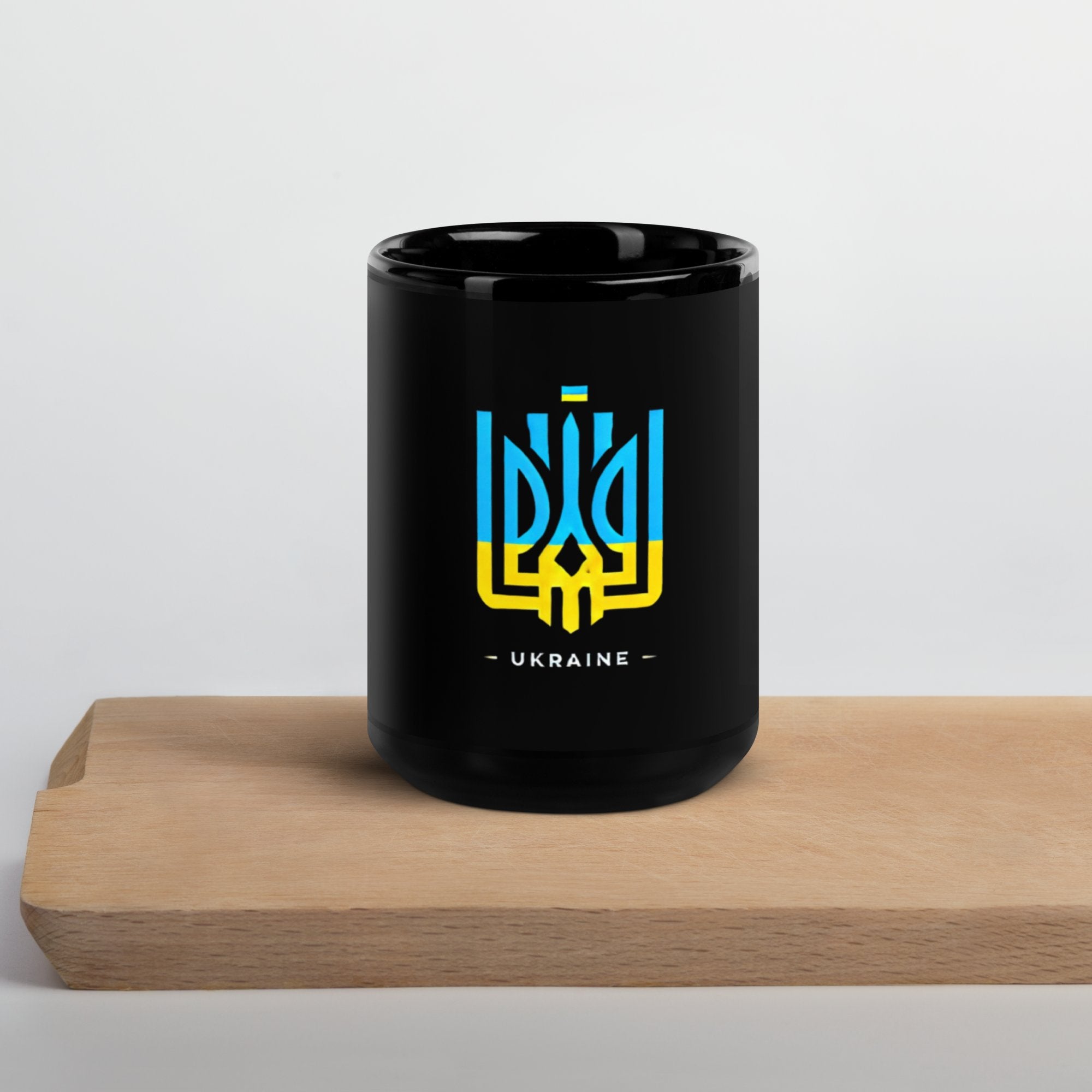Black mug with Ukraine emblem and text on a wooden board for home and living collection.