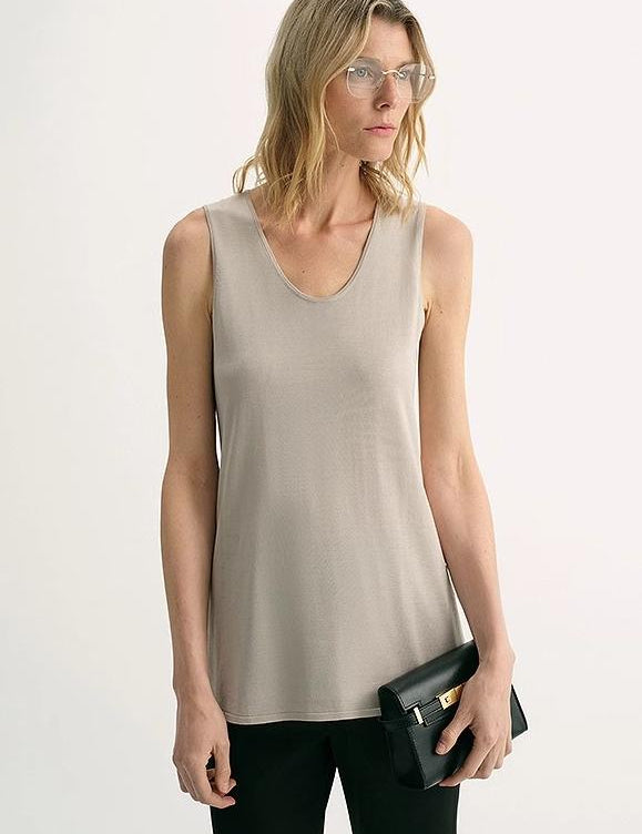 Woman wearing Sylvenia fine silk knit vest with U-neckline, styled with black pants, showcasing elegant and effortless fashion.