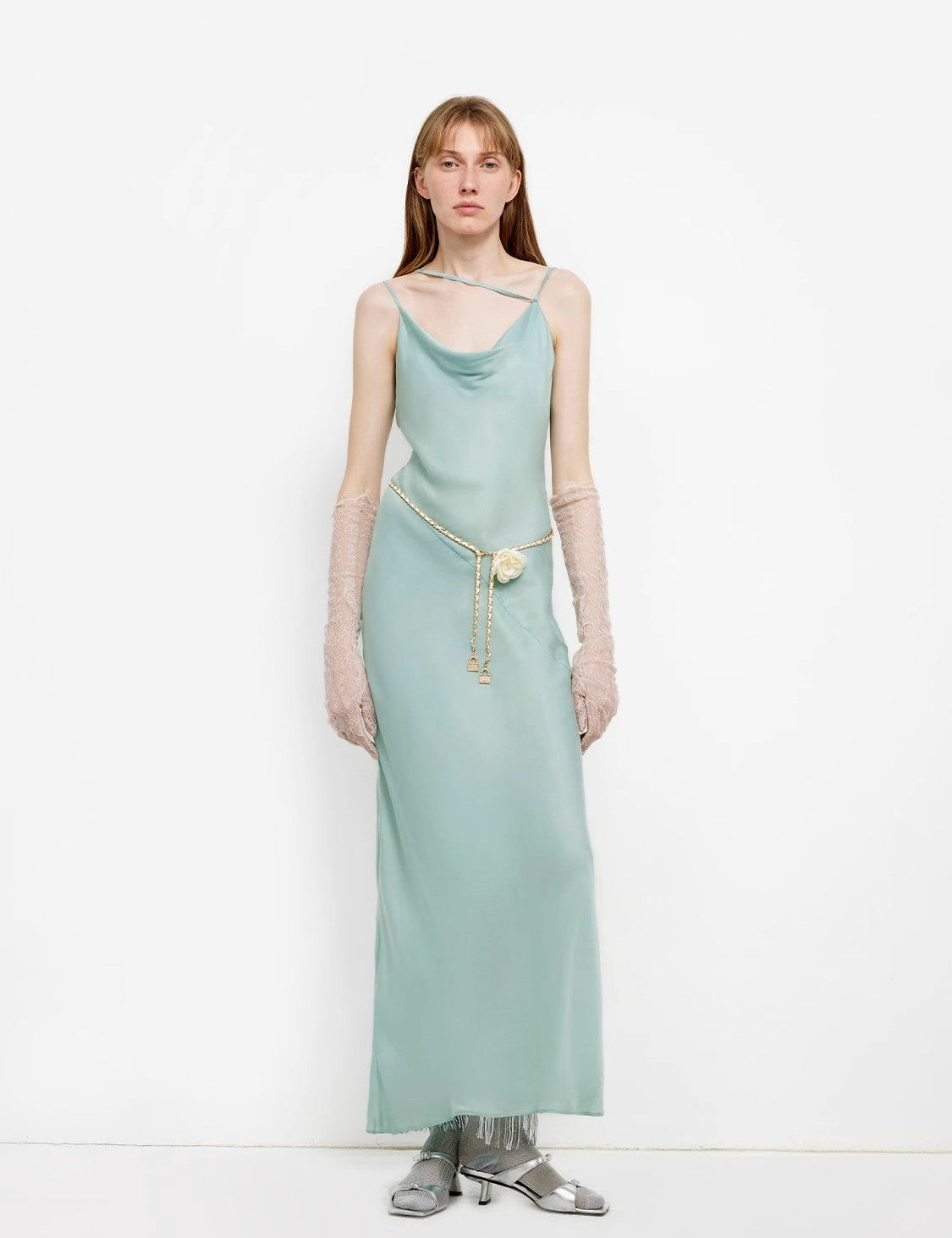 Model wearing a sophisticated mint green satin gown with adjustable straps, complemented by gloves and silver shoes, perfect for evening events.