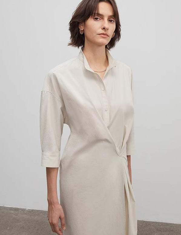 Woman wearing an Origami Trace Wrap Dress with stand collar and wrap silhouette in high-density cotton.