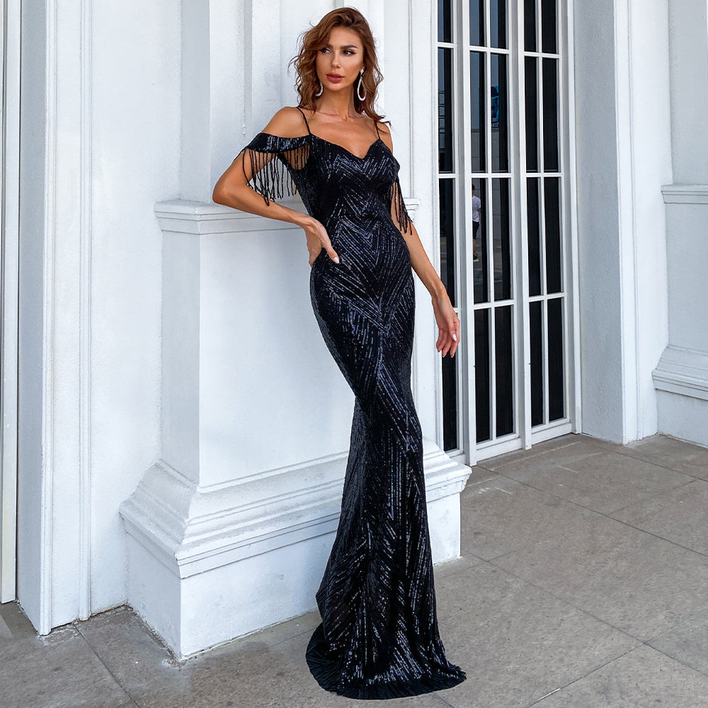 Elegant woman wearing a Serelina Sequin Tassel Gown, showcasing a shimmering black sequin fabric with dramatic tassels, ideal for evening events.