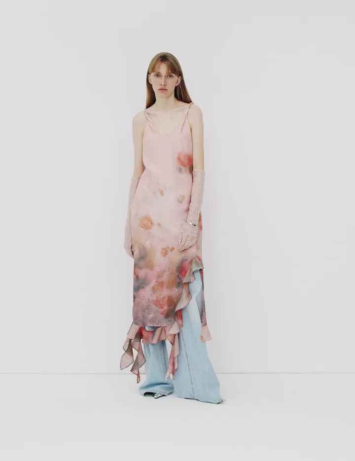 Model wearing floral pink and blue layered maxi dress with twist straps, showcasing elegant and romantic summer fashion.