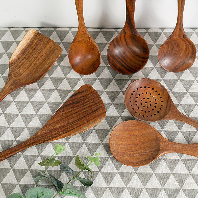 Teak wood spatulas set on geometric tablecloth, featuring non-stick stir-fry and slotted designs for kitchen use.