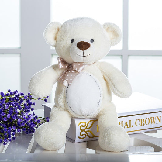 Beige teddy bear plush with bow sitting on books, soft and cuddly stuffed animal for infants.