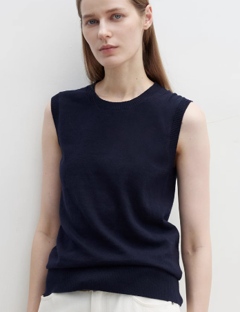 Model wearing Noriven Cottonwool Sweater Vest; navy sleeveless knit with rounded neckline, perfect for layering or standalone wear.