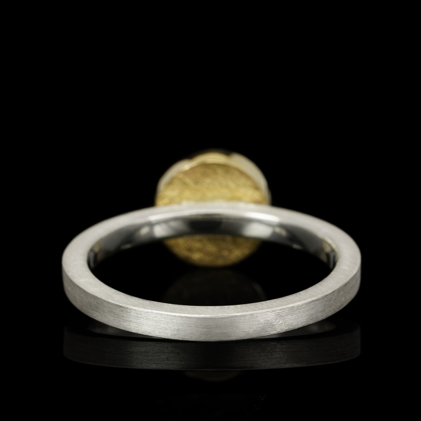 Sterling silver ring with 14K gold accent, side view on black background, showcasing unique celestial-inspired Cosmic Horizon design.