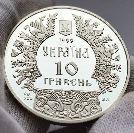 1999 Ukrainian 10-hryvnia silver coin with intricate design, featuring mythical figures and national emblem.