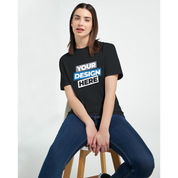 Woman wearing Print on Demand Zalmera Women’s Cotton T-Shirt with customizable design, sitting on a stool.