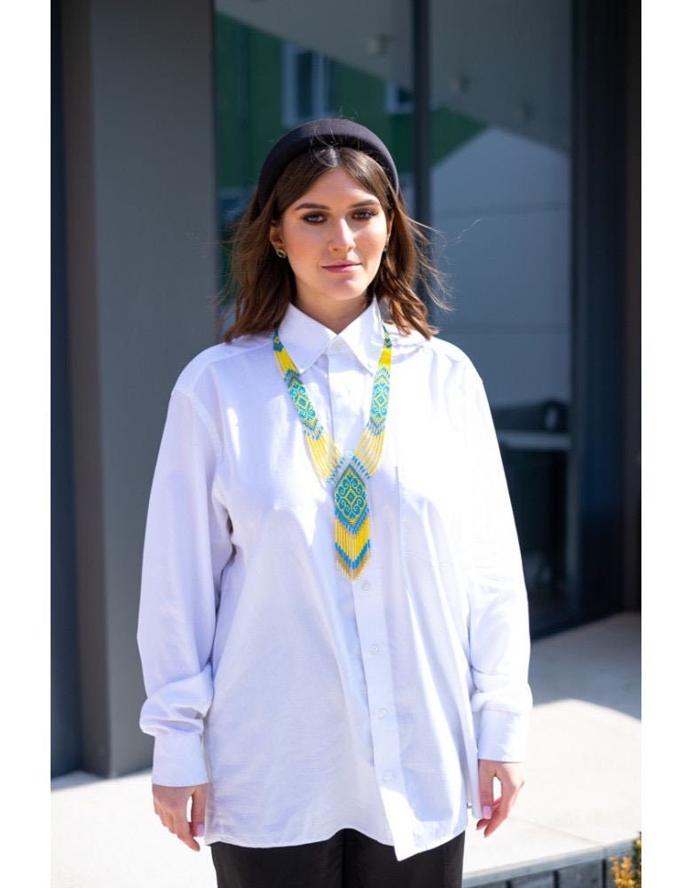 Woman wearing 2025 handmade Ukrainian gerdan necklace in yellow and blue, showcasing folk jewelry style.