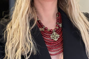 Close-up of red Ukrainian necklace with glass beads and bronze charms, worn on black outfit, ideal ethnic jewelry gift for her.
