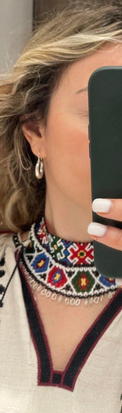 Woman wearing a 2025 Traditional Ukrainian Sylyanka necklace handmade with vibrant Czech seed beads and geometric patterns.