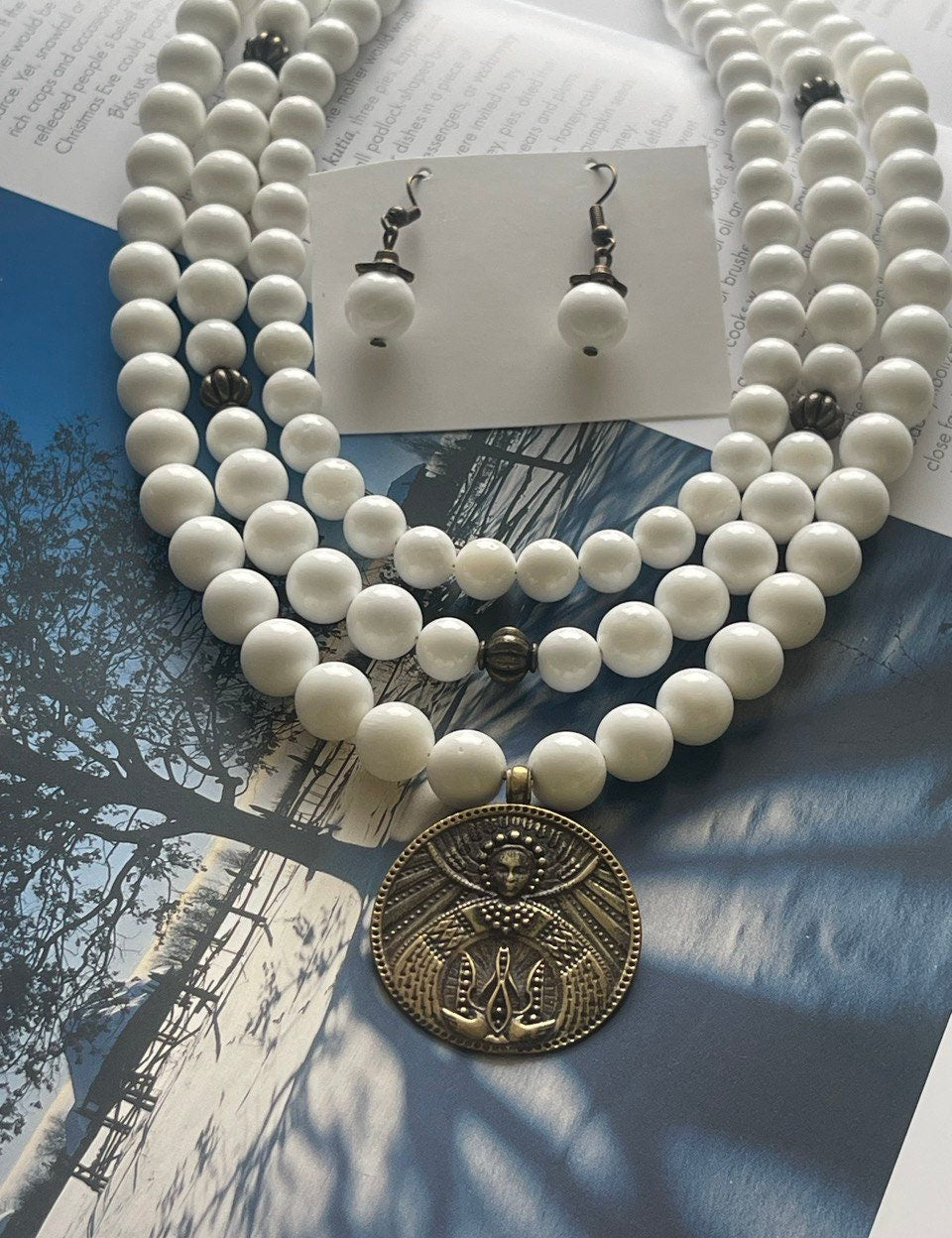 Handmade Ukrainian white mother-of-pearl necklace with ethnic pendant on display, showcasing elegance and cultural charm.