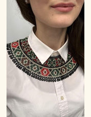 Woman wearing a handmade Ukrainian Kryza necklace with green, beige, and red beads, styled as a traditional collar.