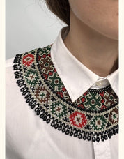 Green beaded Ukrainian Kryza necklace in traditional folk style adorning a white shirt collar.