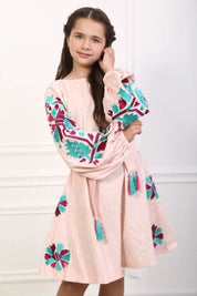 Girl wearing 2025 pink linen embroidered Ukrainian boho dress with folk-style patterns and belt, showcasing elegance and tradition.