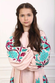 Girl wearing a 2025 pink linen embroidered dress with Ukrainian boho vyshyvanka design and belt, featuring long gathered sleeves.