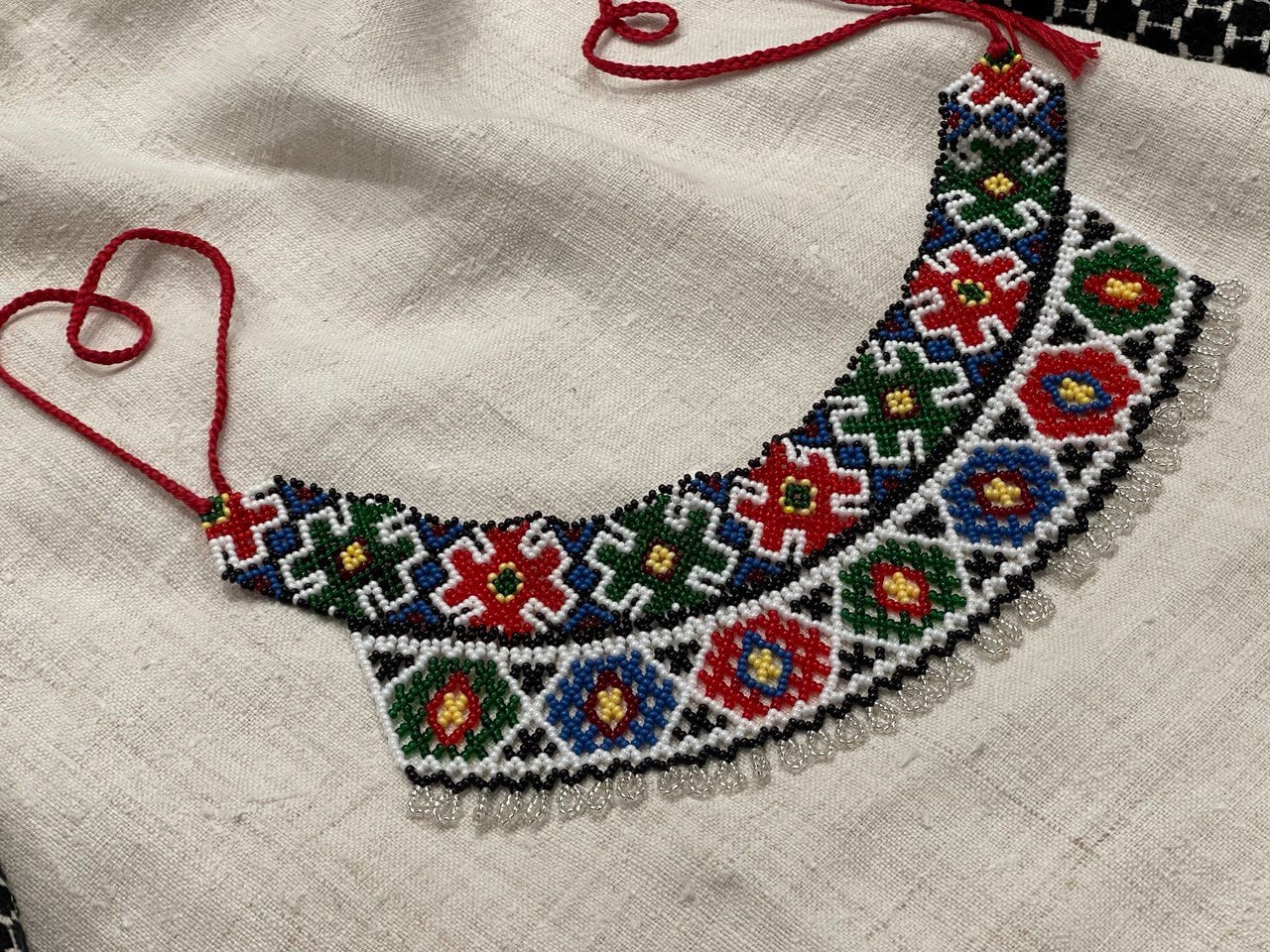 2025 Handmade Ukrainian Sylyanka necklace with colorful Czech seed beads on linen background