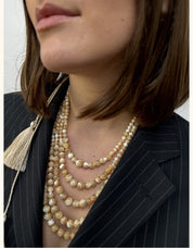 Five-strand golden mother-of-pearl necklace, elegant Ukrainian folk jewelry, paired with a black pinstripe suit.