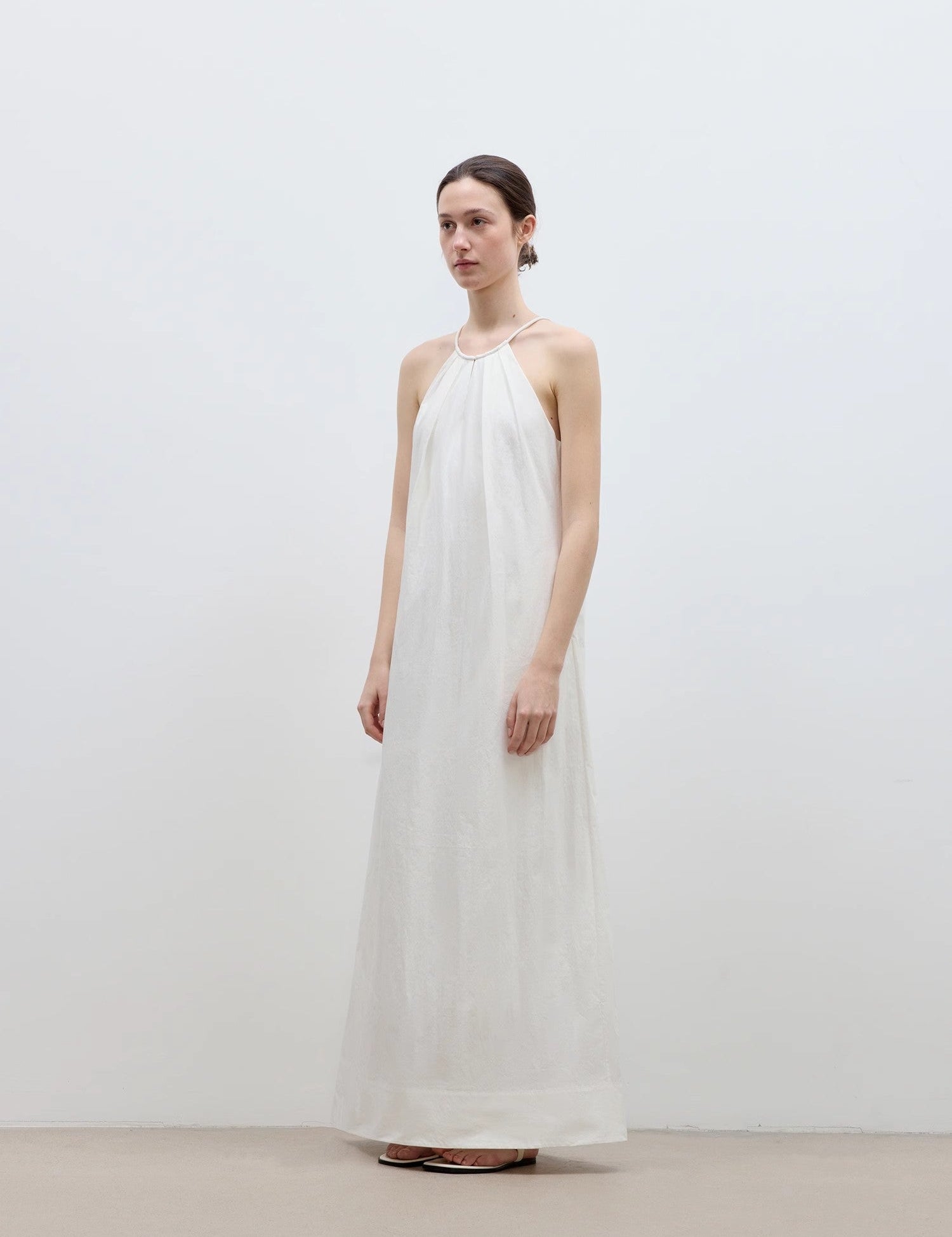 White Veridia Halter-Pleat Maxi Dress with cotton-rope halter and pleated neckline, featuring a fluid skirt finishing at the ankle.