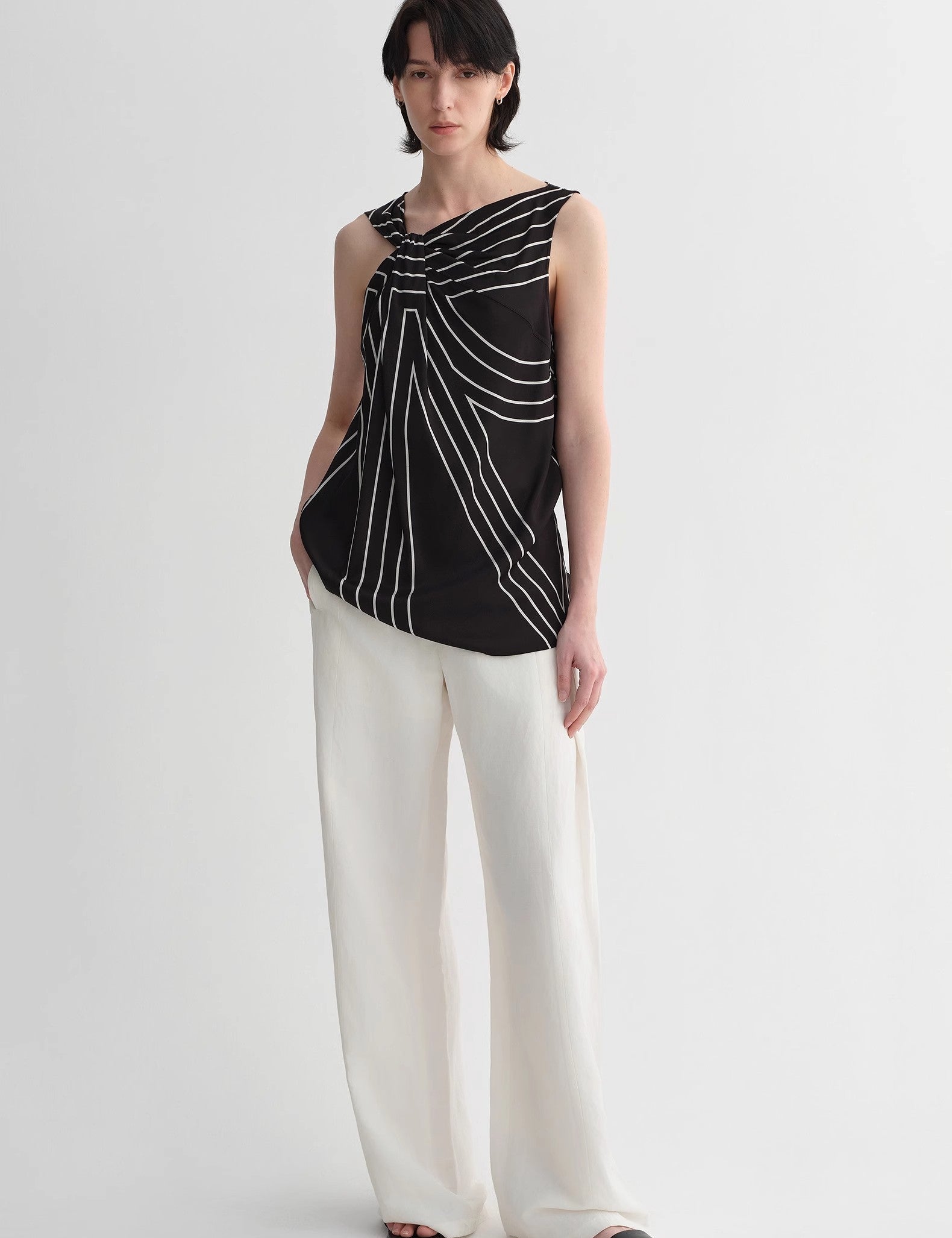 Alt Tag: Model wearing Seravelle Twisted Silk Vest with geometric black and white pattern, showcasing the draped collar and elegant silhouette.