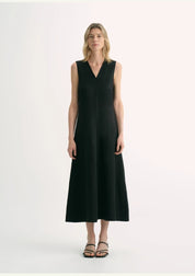 Woman wearing black Aurevae cupro-linen A-line dress with V-neck and sleeveless design, displaying elegant and breathable style.