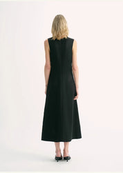 Back view of a woman wearing a sleeveless black Aurevae Cupro-Linen A-Line Dress with a V-neck and mid-calf length silhouette.