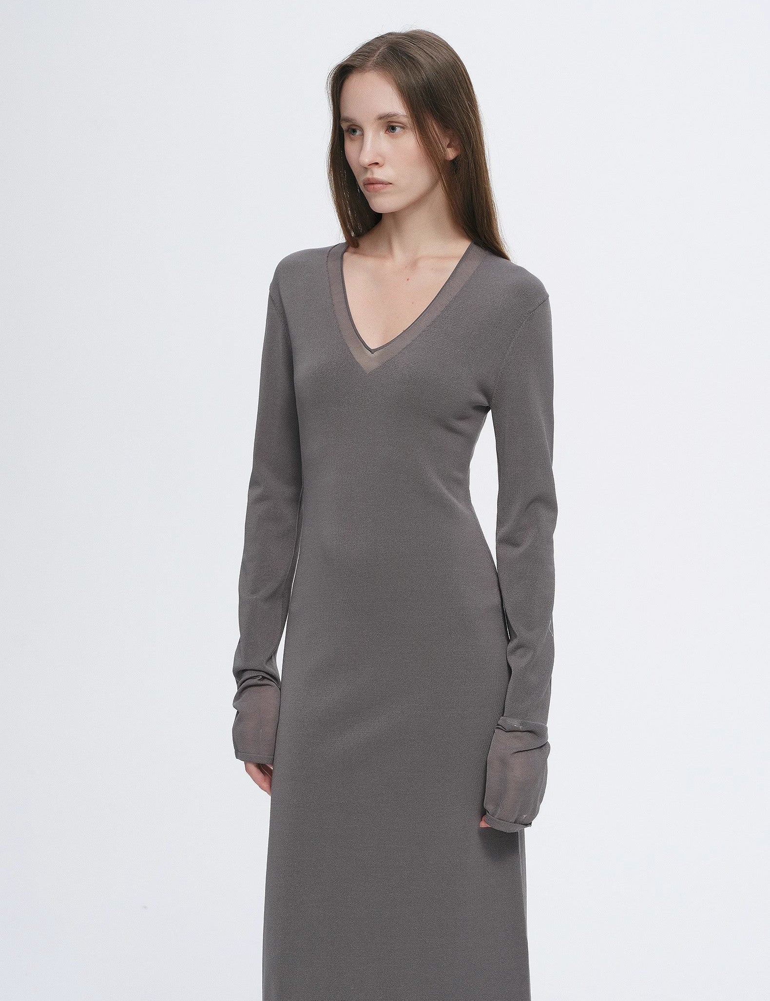 Woman wearing Virella Mesh-Splice V-Neck Dress with minimalist design and sheer mesh panels in gray.