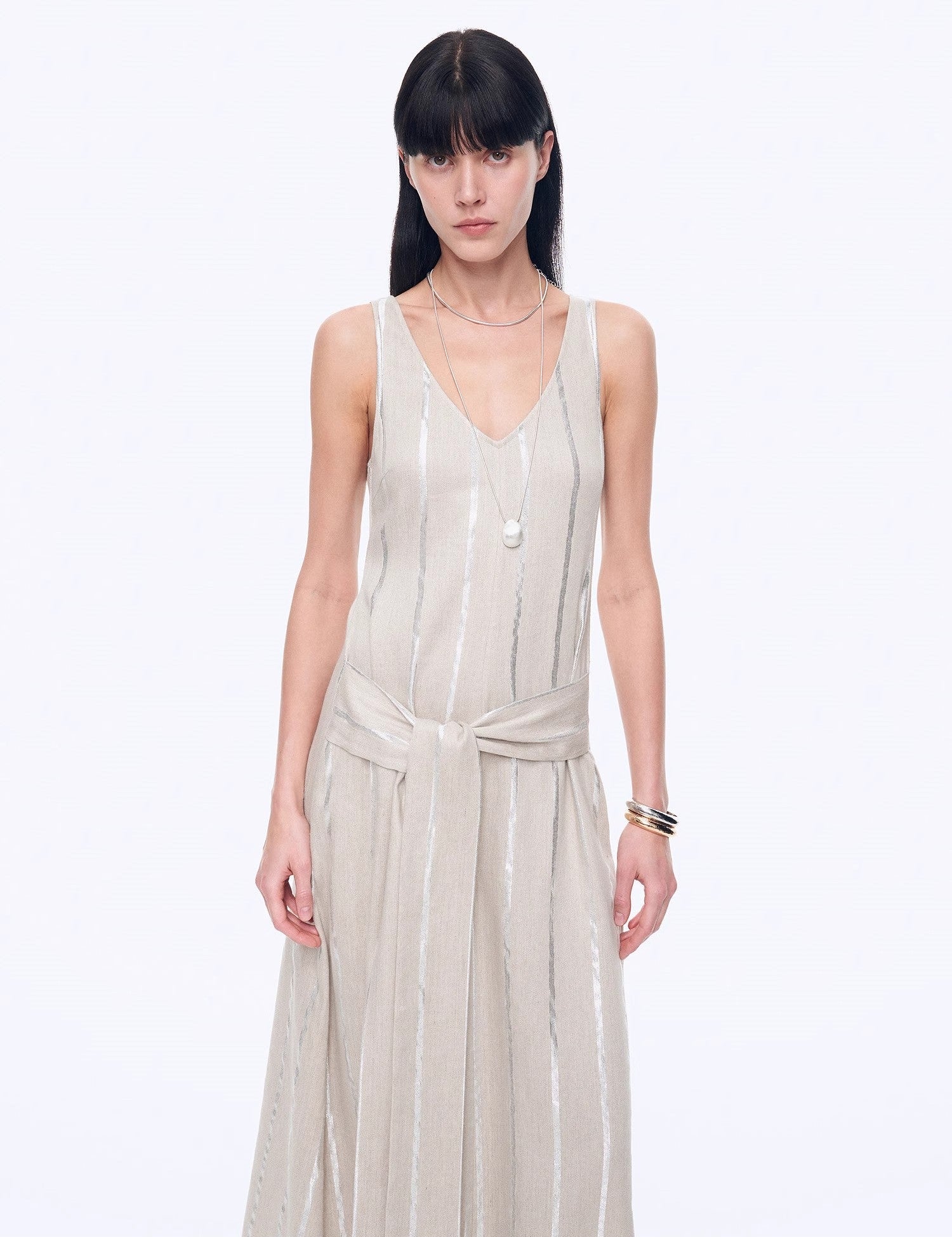 Alt Tag: Woman wearing Milira Silver Stripe Linen Drape Dress with V-neck bodice and adjustable belt, showcasing elegant A-line silhouette.