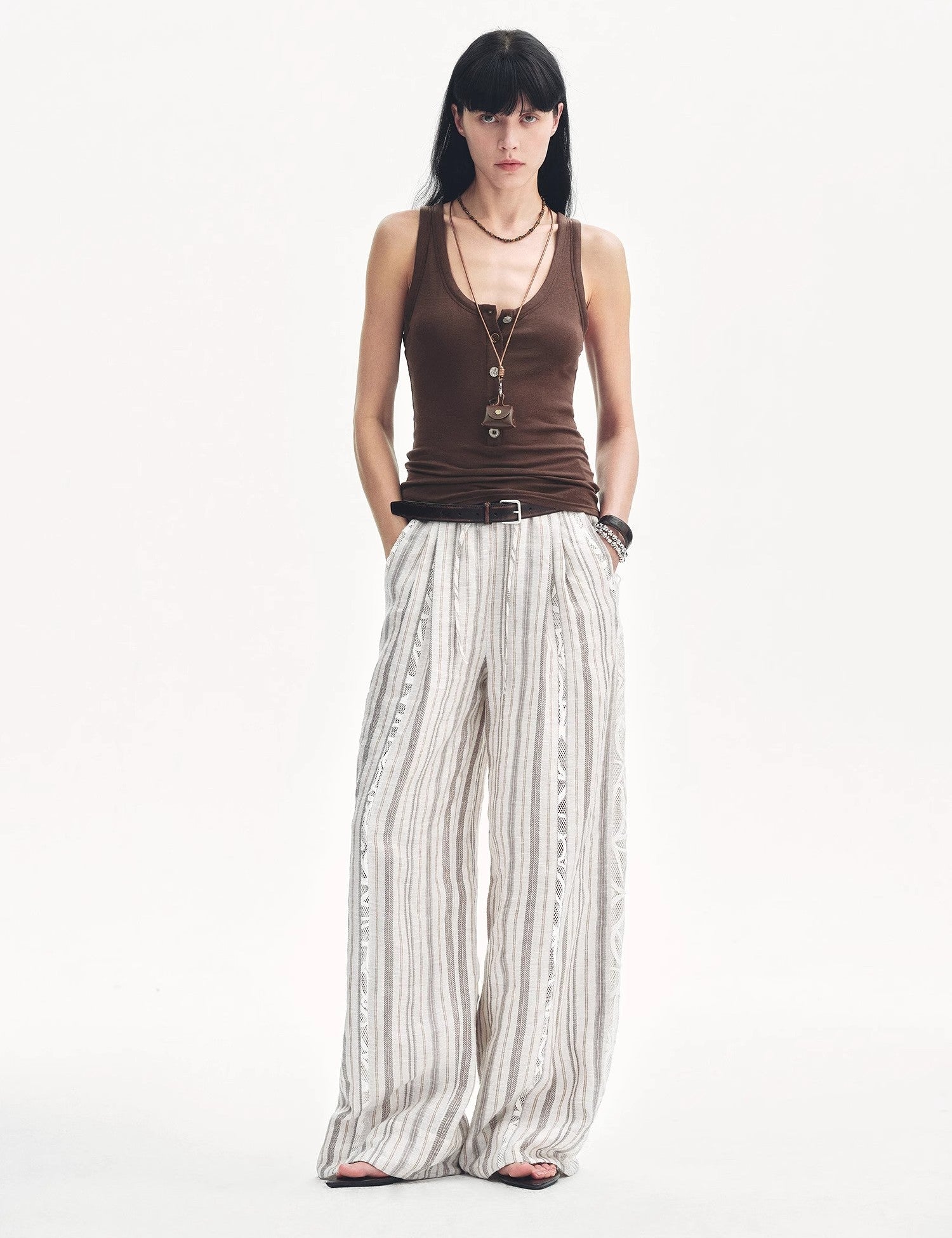 Model wearing Lureva U-Henley vest with wide straps and striped wide-leg pants, showcasing minimalist and breathable summer fashion.