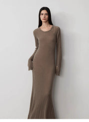 Woman wearing Fray Line wool knit dress with frayed edges and cut-outs, showcasing edgy style and comfort in taupe color.