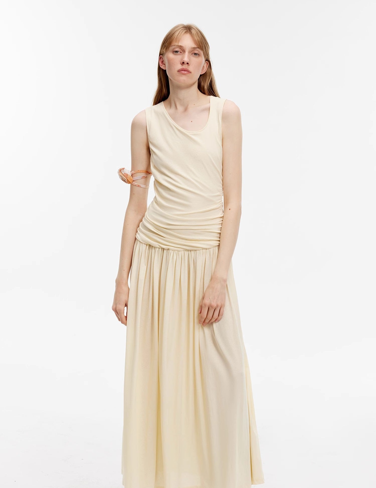 Model wearing Calvara Pleated Cotton Maxi Dress in off-white, featuring asymmetrical collar and pleated hem for a relaxed elegance.