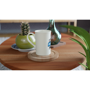 Print on demand slim white porcelain mug 10oz on a wooden table with plants, perfect for daily coffee or hot chocolate.