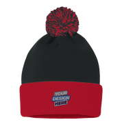 Black and red knit pom beanie with "Your Design Here" text, featuring fold-over cuff for custom embroidery, made from warm acrylic.