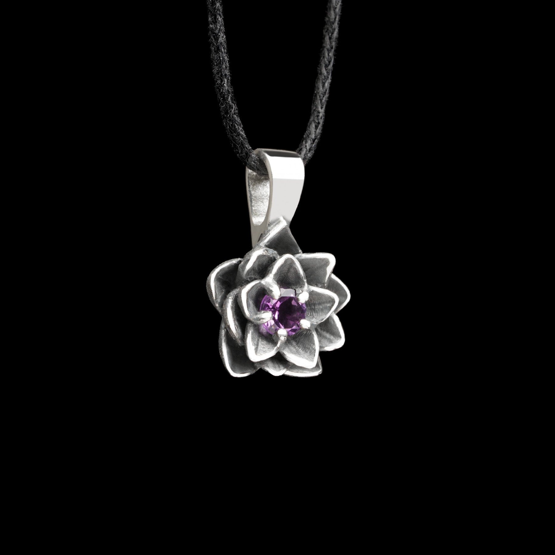 Sterling silver "Blooming Heart" pendant with amethyst, resembling a lotus flower, on a black background.