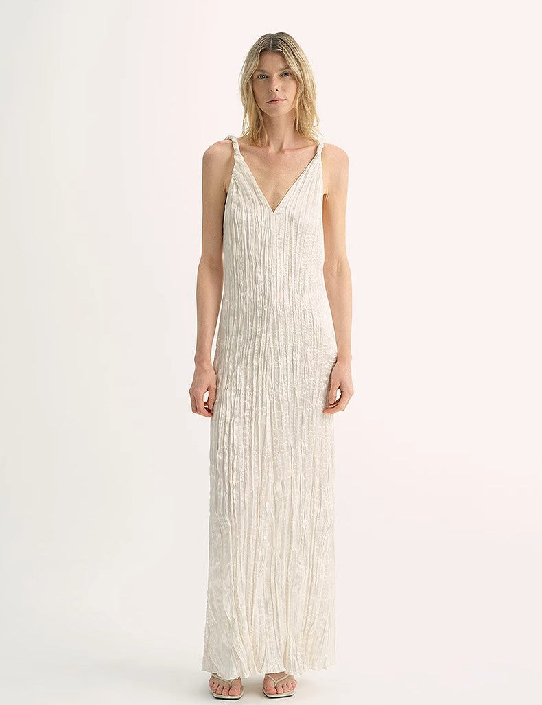 Woman wearing Veylani Wave-Pleat V-Neck Dress, showcasing elegant pleats and three-dimensional drape in a soft, silky fabric.
