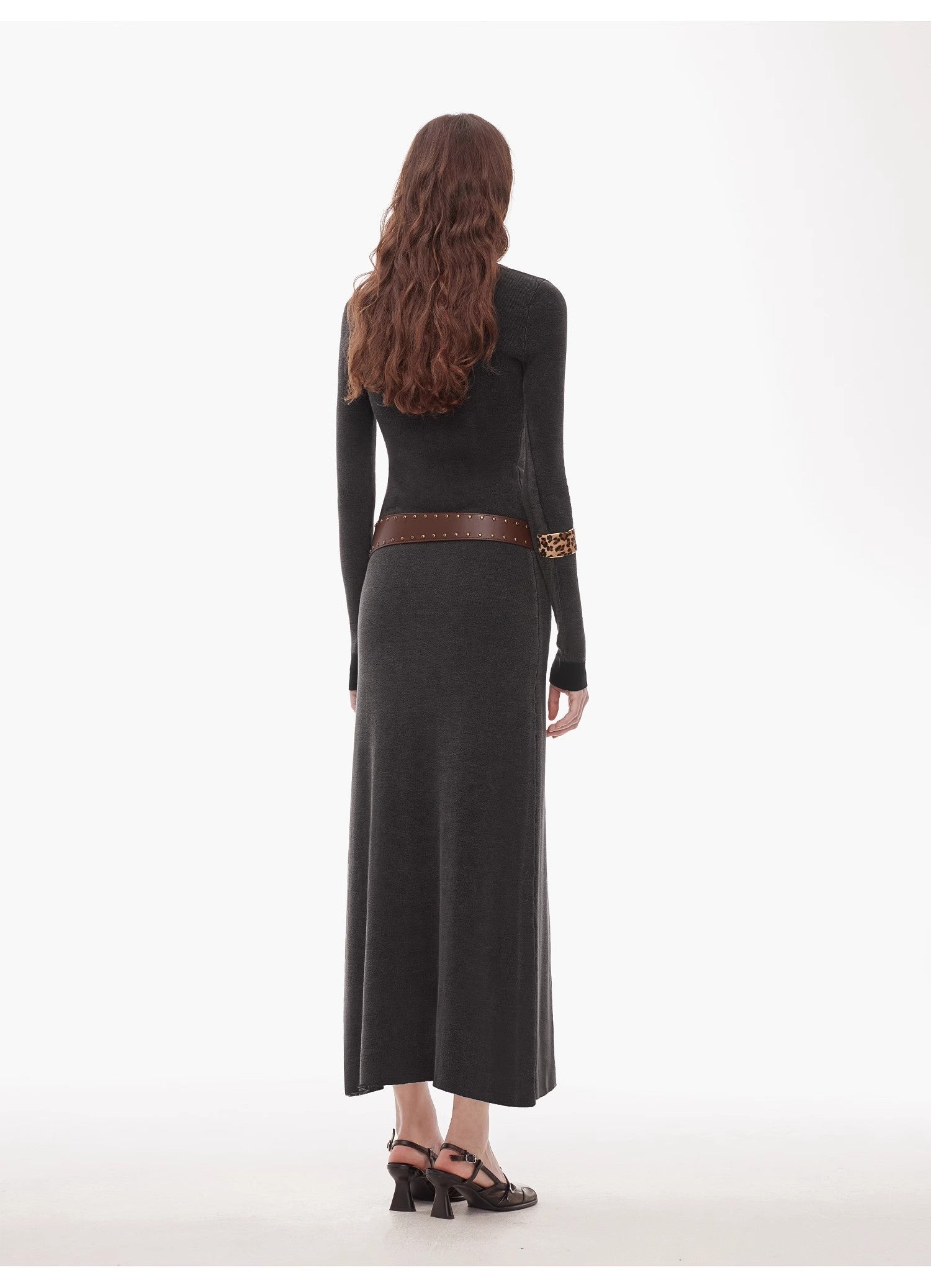 Woman wearing Selvara distressed cotton V-neck dress with contrast cuffs, viewed from the back, showing slim waist and textured fabric.