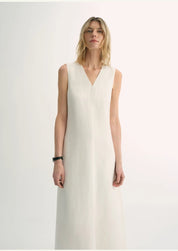 Model wearing Aurevae Cupro-Linen A-Line Dress in white with V-neck and sleeveless bodice, showcasing lightweight fabric and mid-calf silhouette.