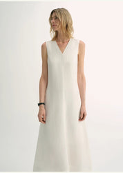 Woman wearing Aurevae Cupro-Linen A-Line Dress with V-neck, sleeveless design, and mid-calf length in light fabric with subtle sheen.