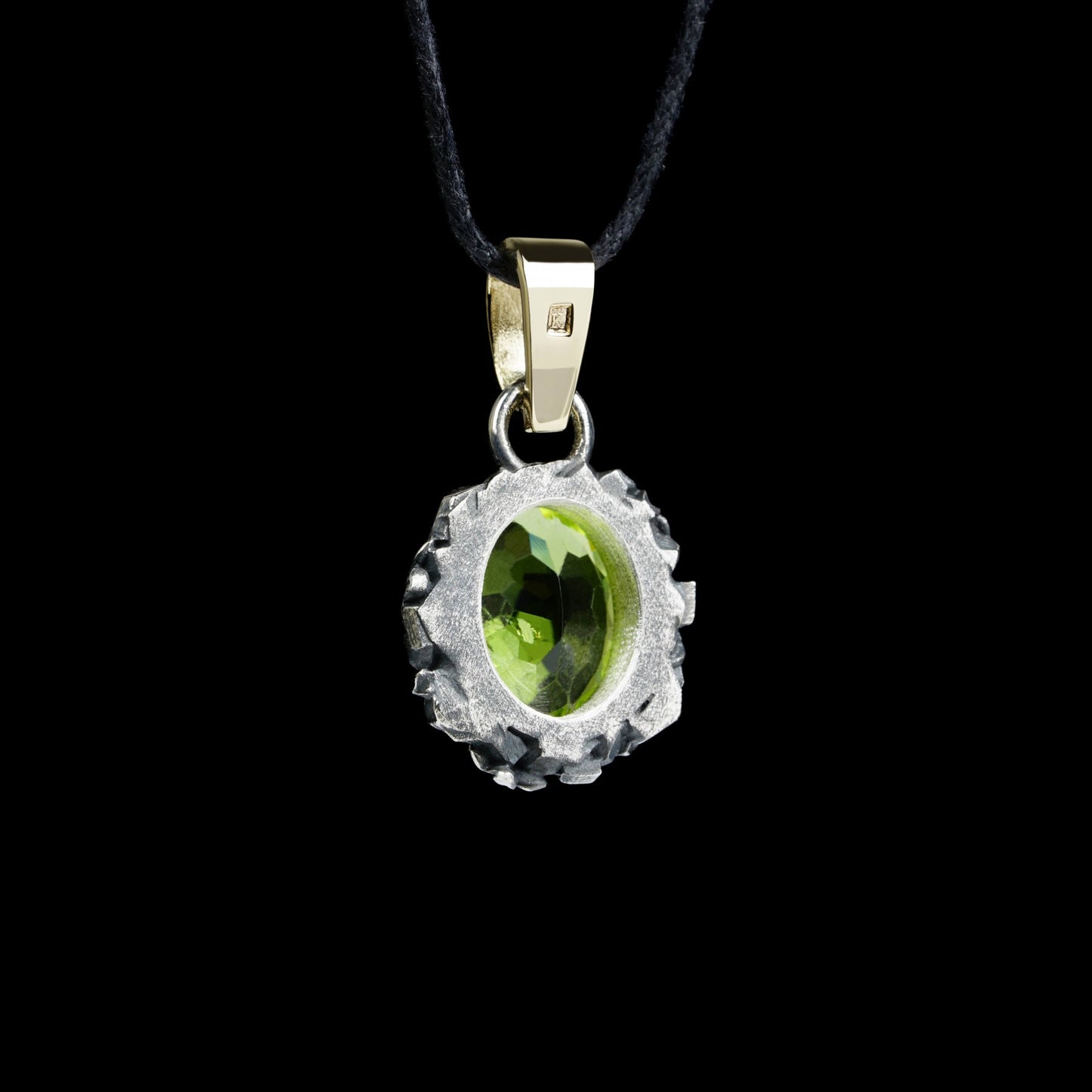 Enchanted Bloom Pendant with oval peridot centerpiece, surrounded by intricate silver flowers and a 14K gold clasp, on a black cord.