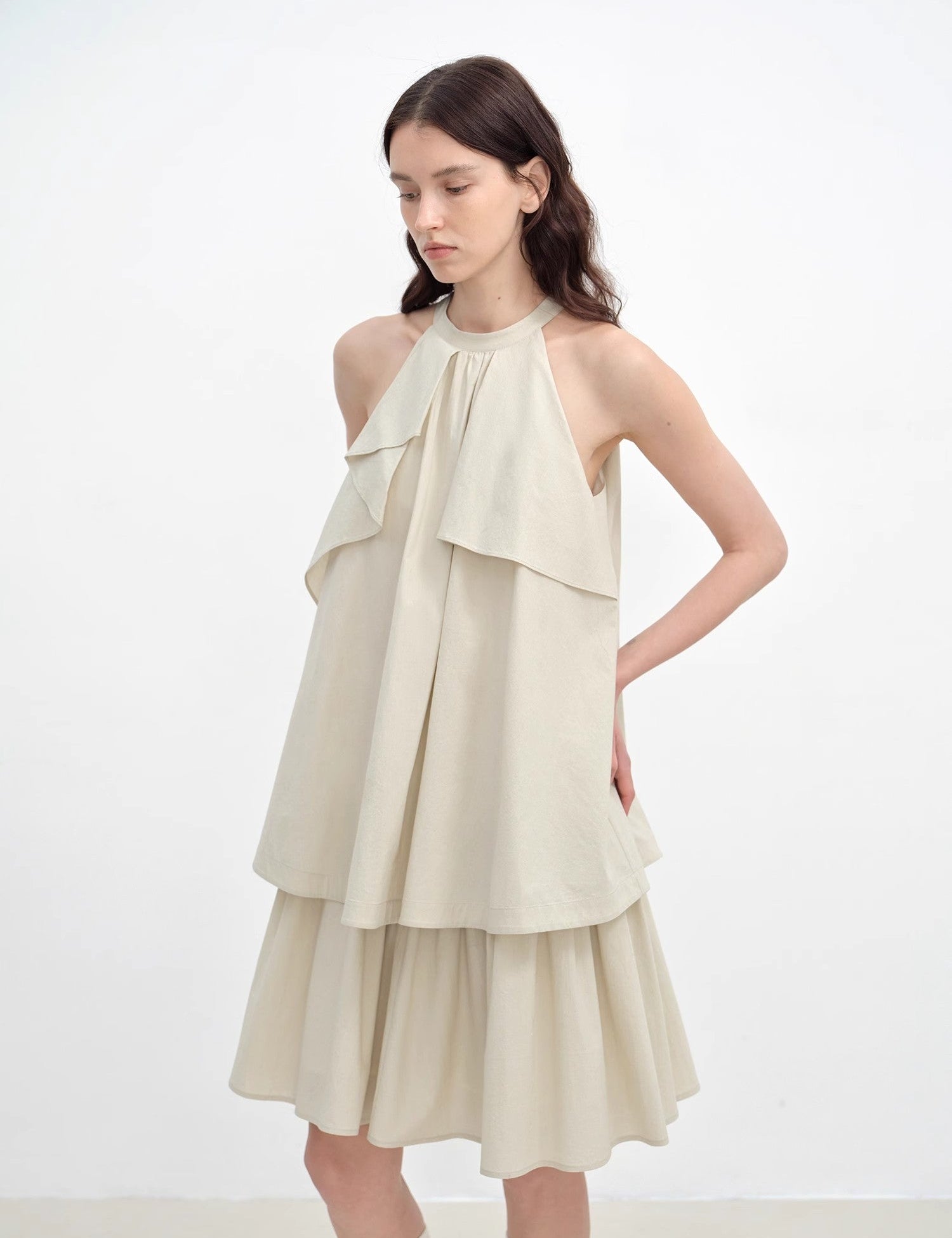 Woman wearing Islanda Textured Cotton Halter Dress with A-line shape and asymmetric pleated neckline.