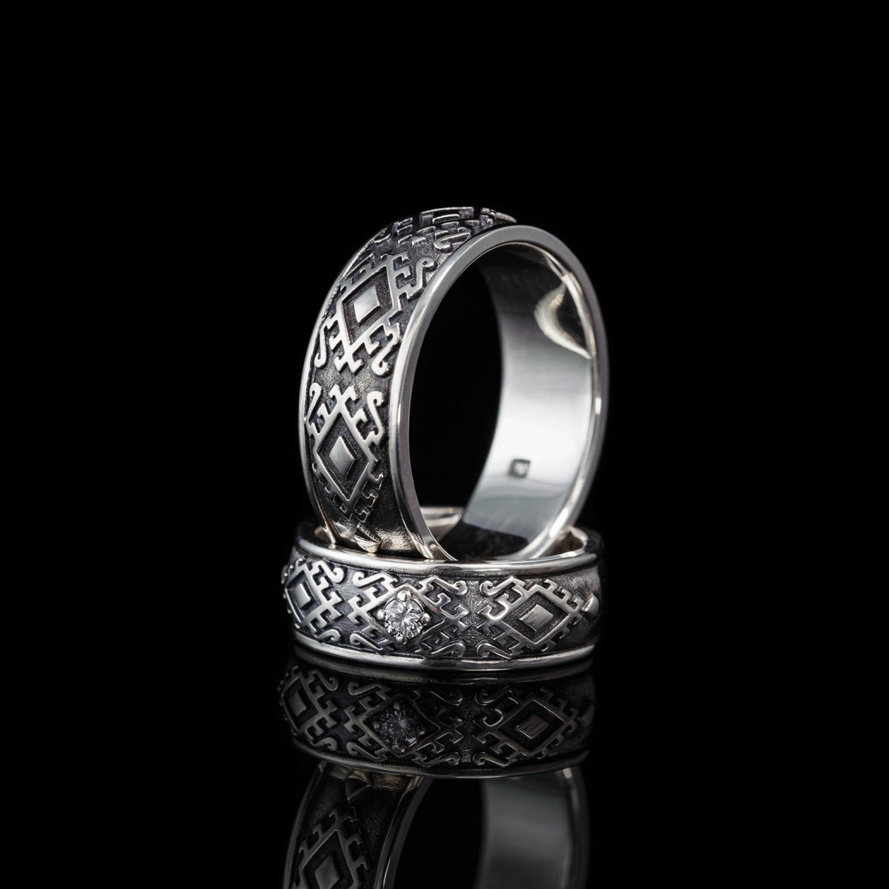 Sterling silver "Carpathian Harmony" wedding rings with oxidized finish, featuring traditional Hutsul design and natural diamond.