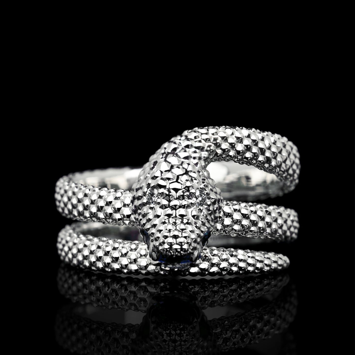 White gold snake motif ring "Serpent Symphony" with sapphire and diamonds on black background, luxury statement jewelry.