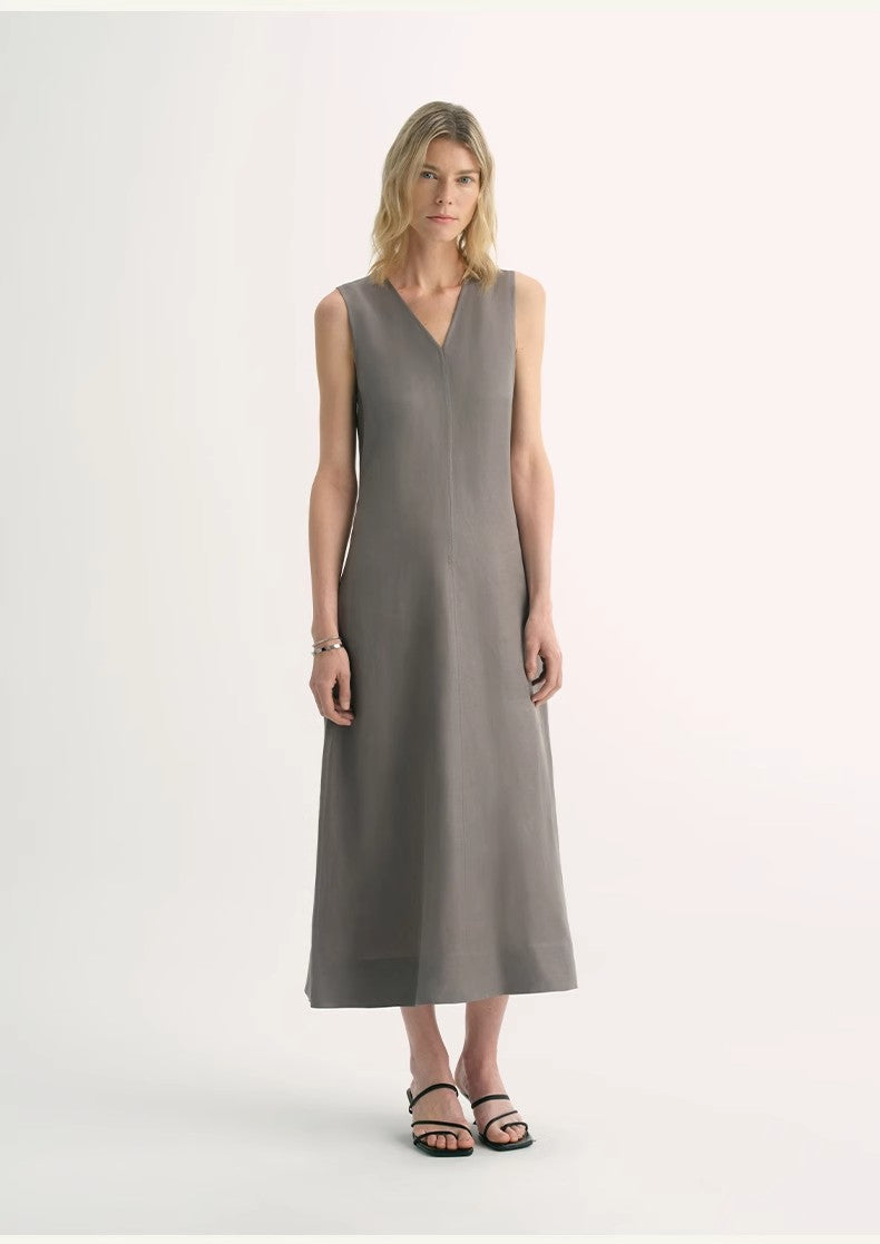 Woman wearing Aurevae Cupro-Linen A-Line Dress with V-neck and sleeveless design, showing mid-calf length and subtle fabric sheen.
