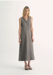 Woman wearing Aurevae Cupro-Linen A-Line Dress with V-neck and sleeveless design, showing mid-calf length and subtle fabric sheen.